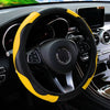 A black steering wheel with a yellow PU carbon fiber cover inside a car interior.