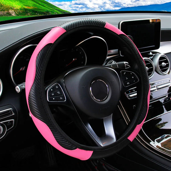 A close-up view of a black steering wheel with a pink PU carbon fiber cover inside a car interior.