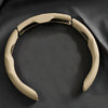 A beige breathable perforated leather steering wheel cover for an auto.