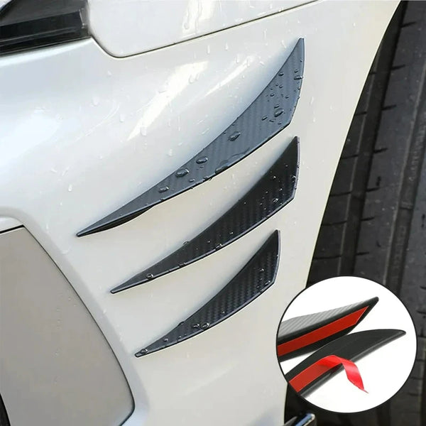 Black universal car spoiler fins installed on a white vehicle's front bumper.