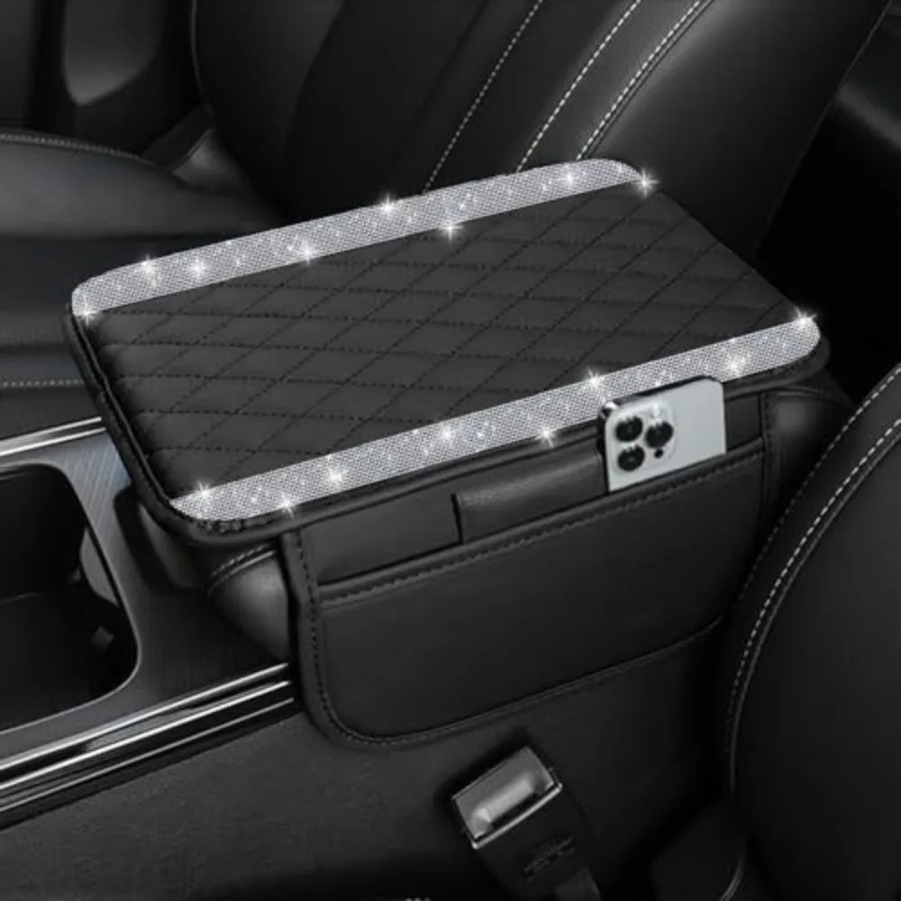 A black car console cover with a diamond grid pattern and a silver accent, resting in a dark interior.