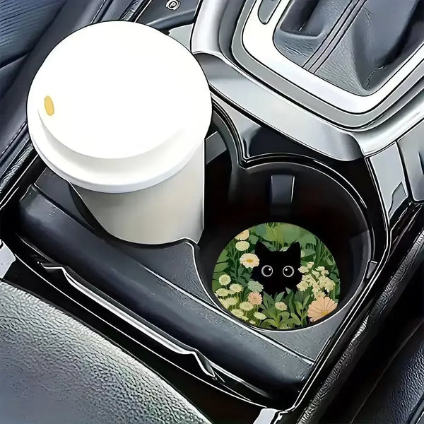 Dos soportes para vasos antideslizantes con diseño de gato negro y flor en un interior oscuro