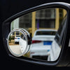 A close-up view of a dual-lens car blind spot mirror set mounted on a vehicle door.