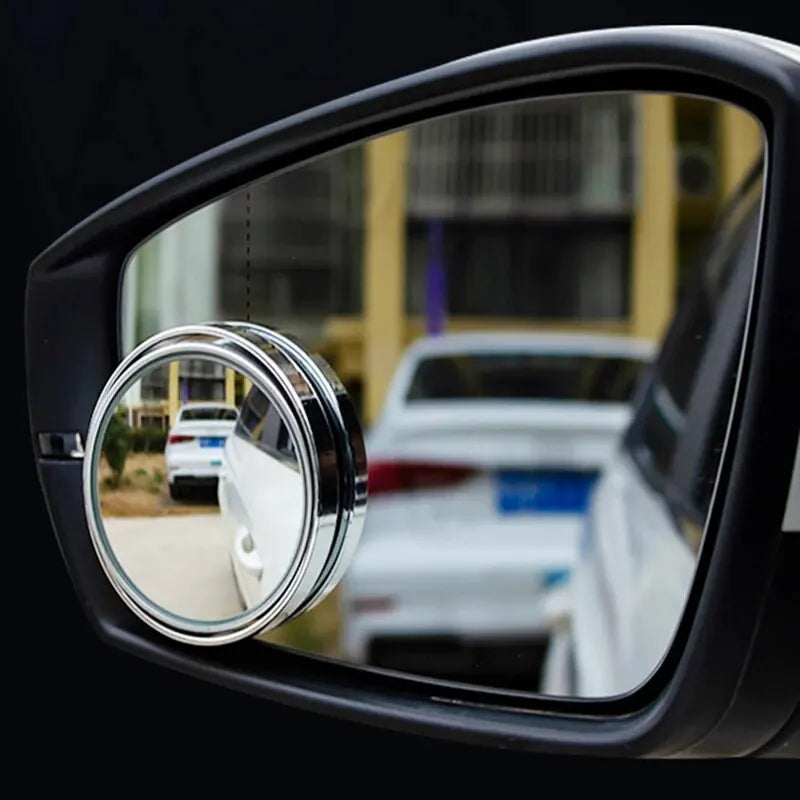 A close-up view of a dual-lens car blind spot mirror set mounted on a vehicle door.