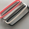Three silicone rearview mirror edge protectors in pink, gray, and white stacked diagonally.
