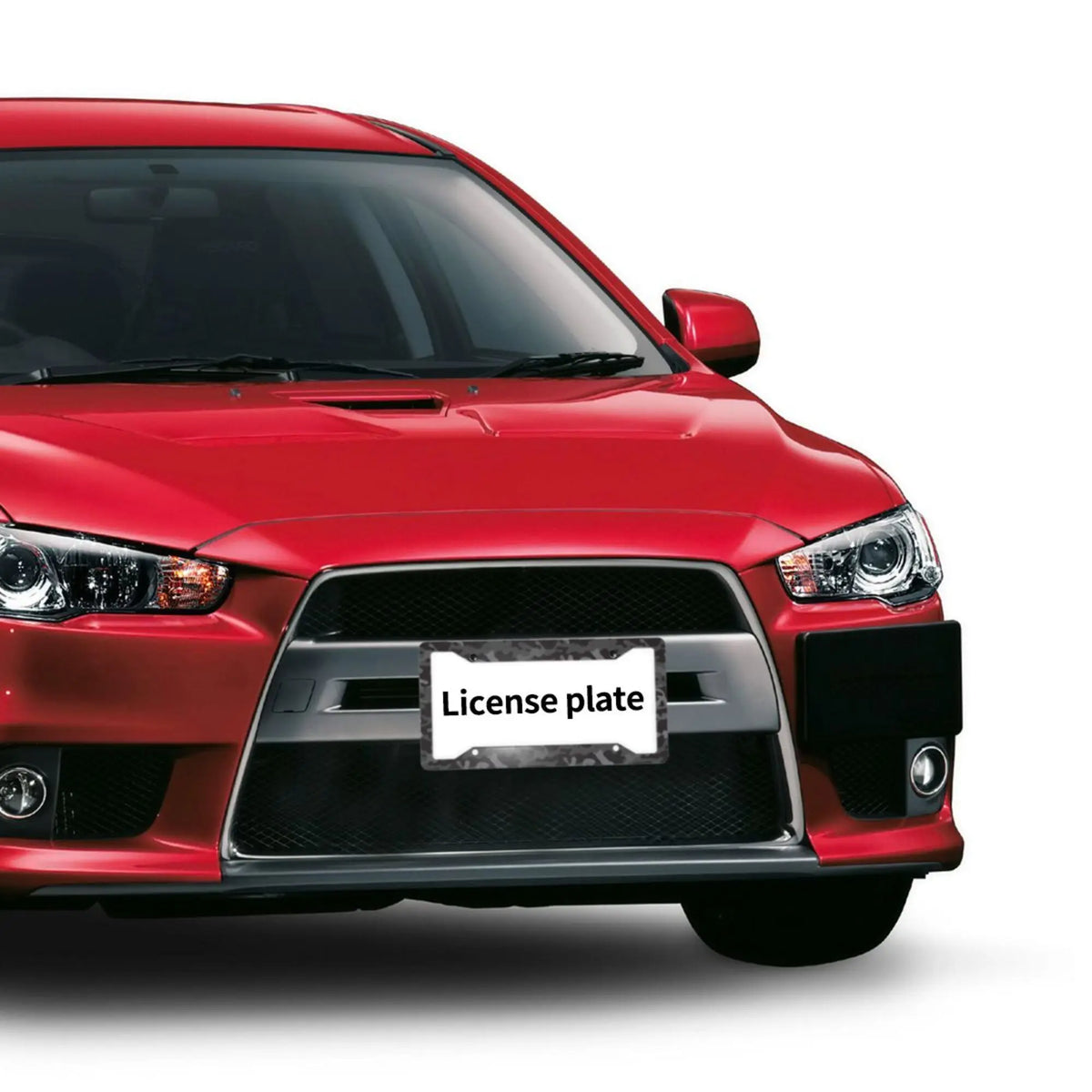 A close-up of a red car's front grille with a license plate frame installed.