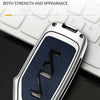 A close-up view of a metallic car key case with a textured dark blue finish resting on a white keyboard.