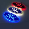 Three oval LED emblems displaying the word Ford in red, blue, and white light.