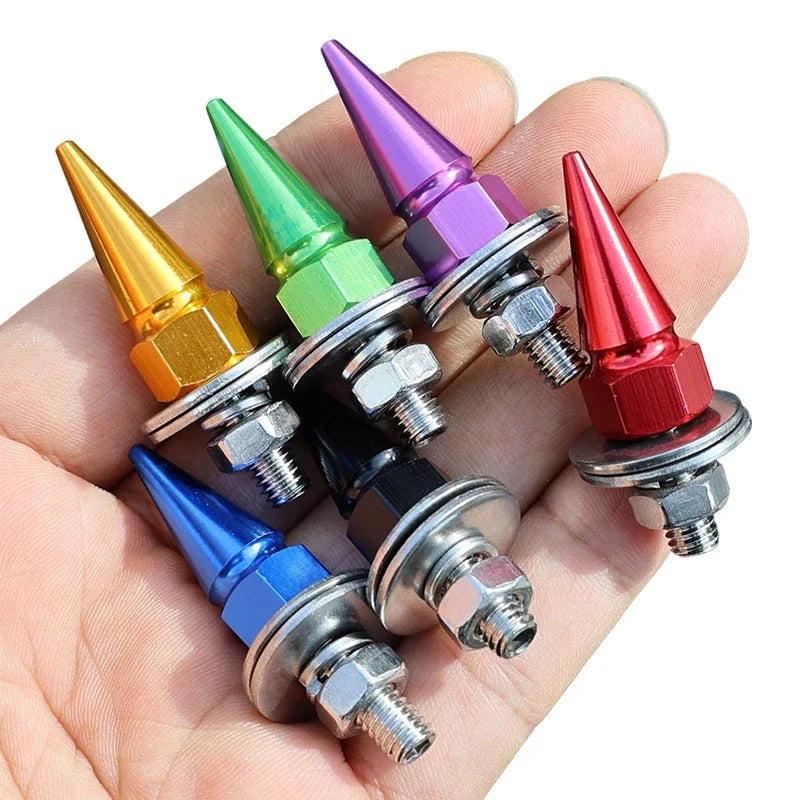 A hand holds several multi-colored M6 license plate fixing screws with conical tips.