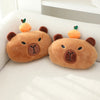 Two brown plush bear-shaped neck pillows with orange ears and green leaves resting on a white surface.