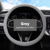 A grey universal silicone steering wheel cover installed on a car's steering wheel.