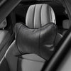 A close-up view of a black ergonomic auto headrest cushion for neck support placed on a car seat.
