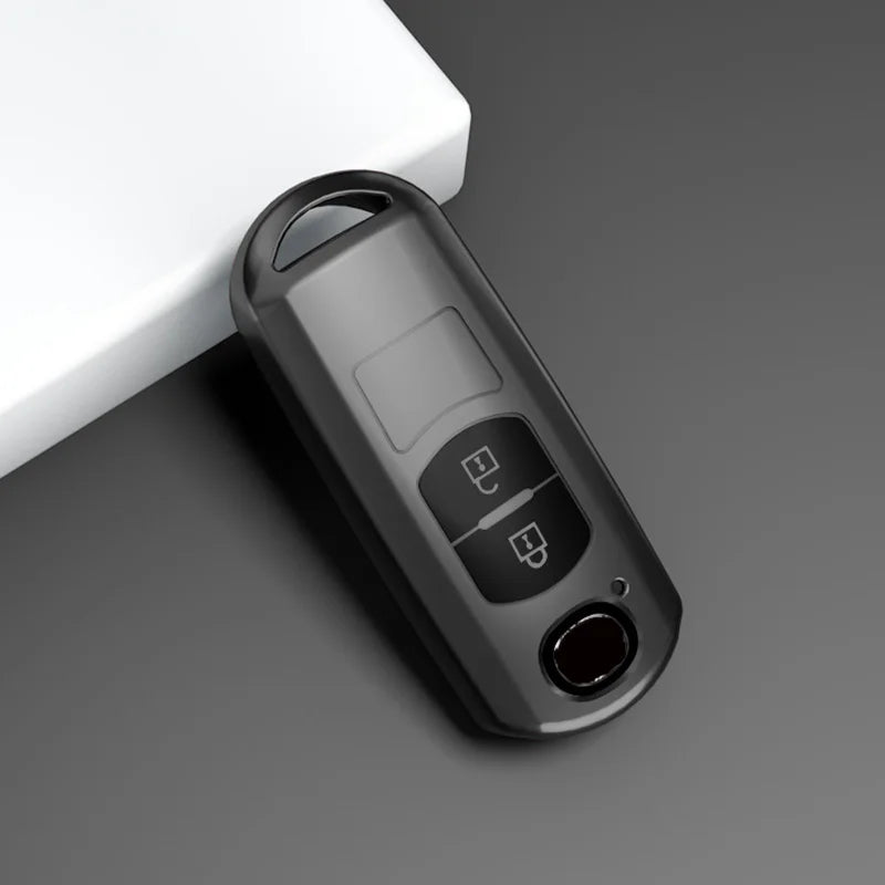 A close-up view of a universal car key cover for Mazda models lying on a gray surface.