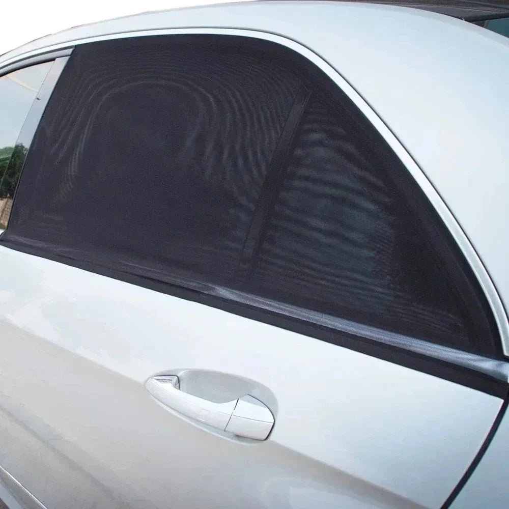 A close-up of a silver car window with a black mesh window screen installed.