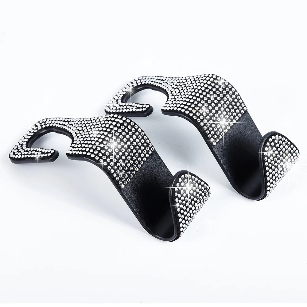 A pair of black car hooks covered in artificial diamond studs for storage.