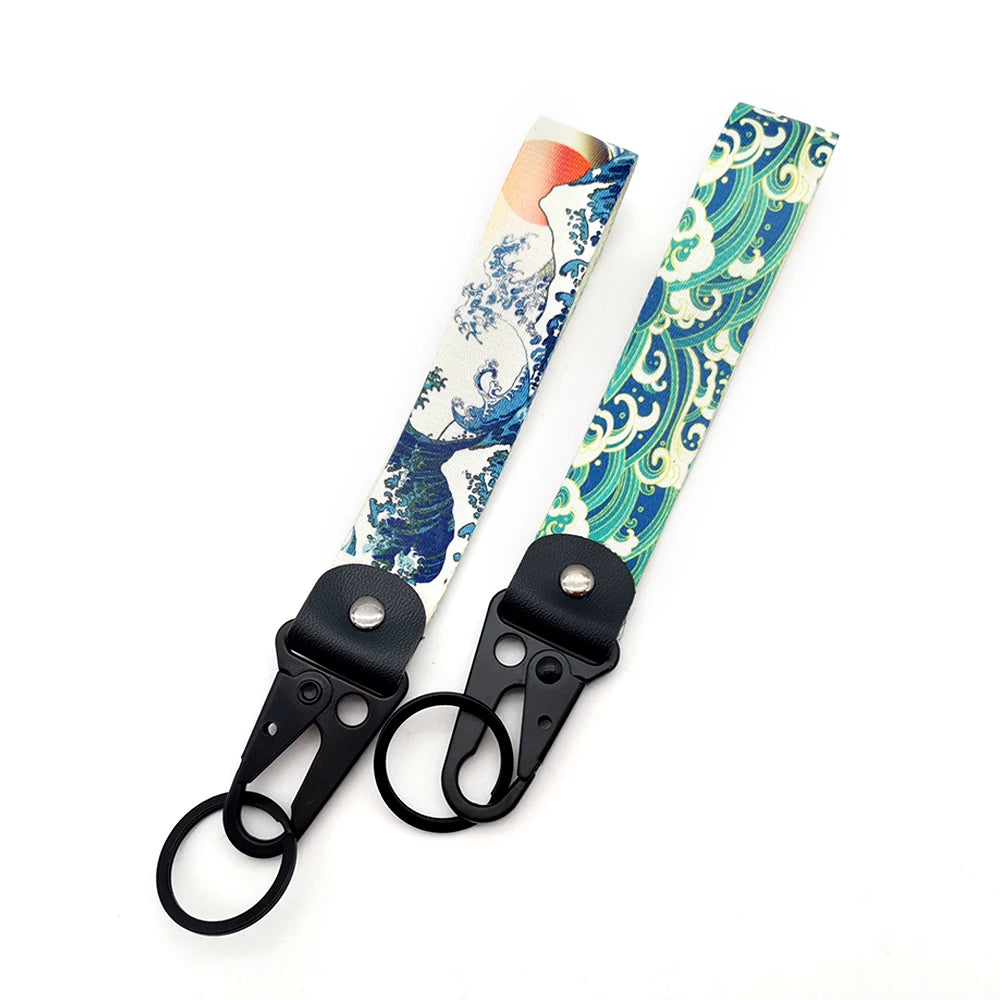 A lanyard featuring a patterned fabric strap with blue and white wave designs and a black metal clip.