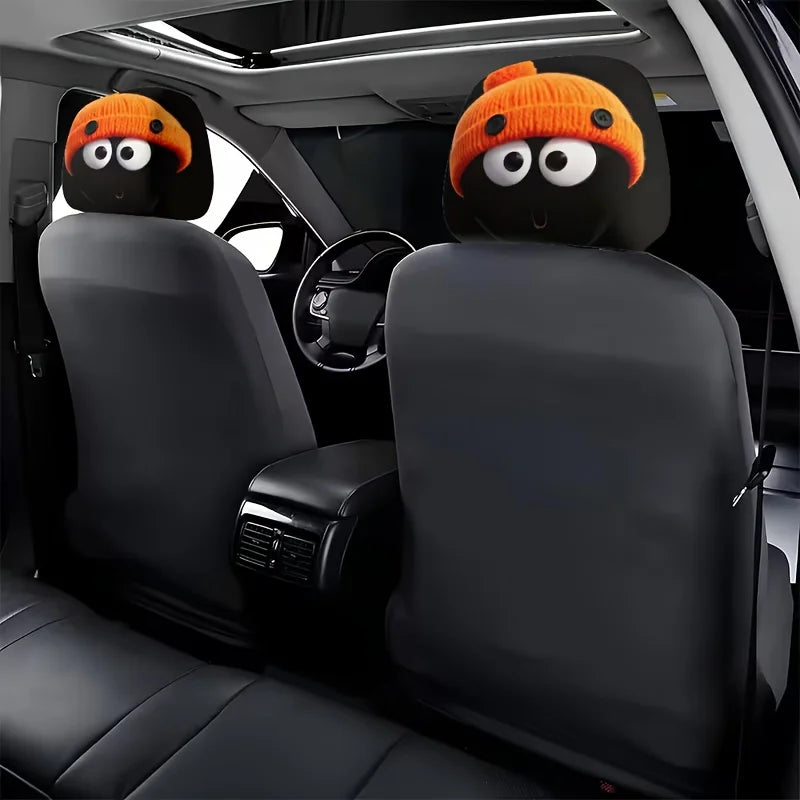 Deux housses de tête d'animal tricotées orange installées sur un siège de voiture noir.