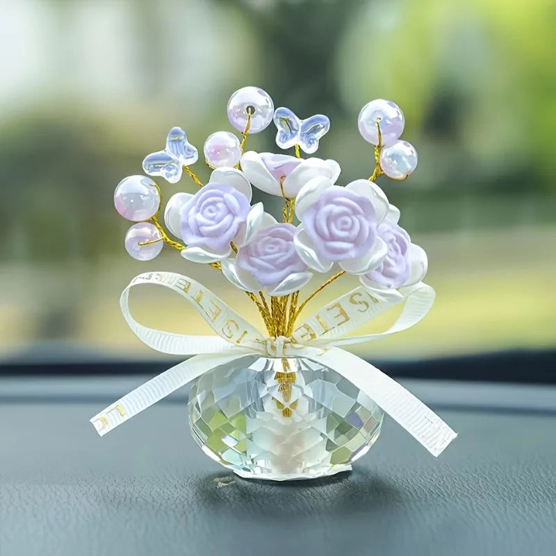 A crystal rose dashboard ornament featuring purple and white faux flowers and butterfly accents.