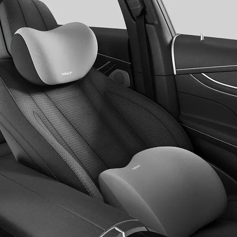 Nahaufnahme eines schwarzen Autositzes mit ergonomischer Kopfstütze und Lendenstützkissen.