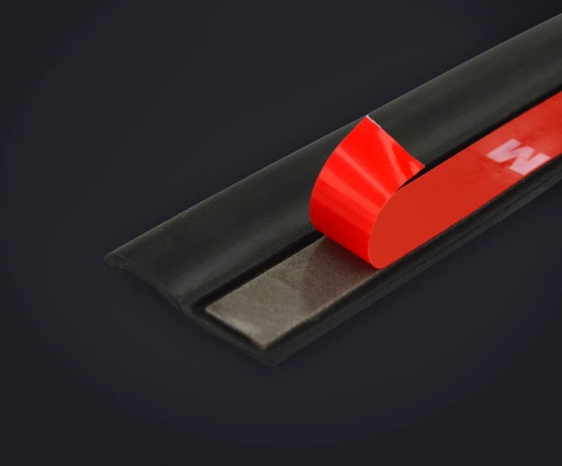A close-up view of a red and black car windshield and body seal strip.