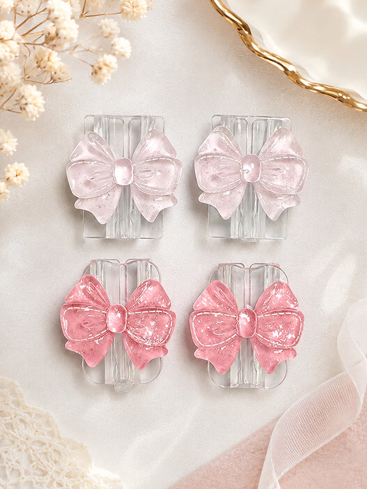 Pink glitter bow cable protectors for lightning and type-C chargers displayed on a light background.