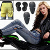 A woman wearing jeans and a leather jacket poses next to a motorcycle with various black waterproof protection covers.