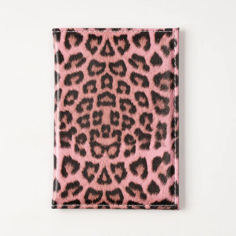 A pink leopard print passport holder with card slots.