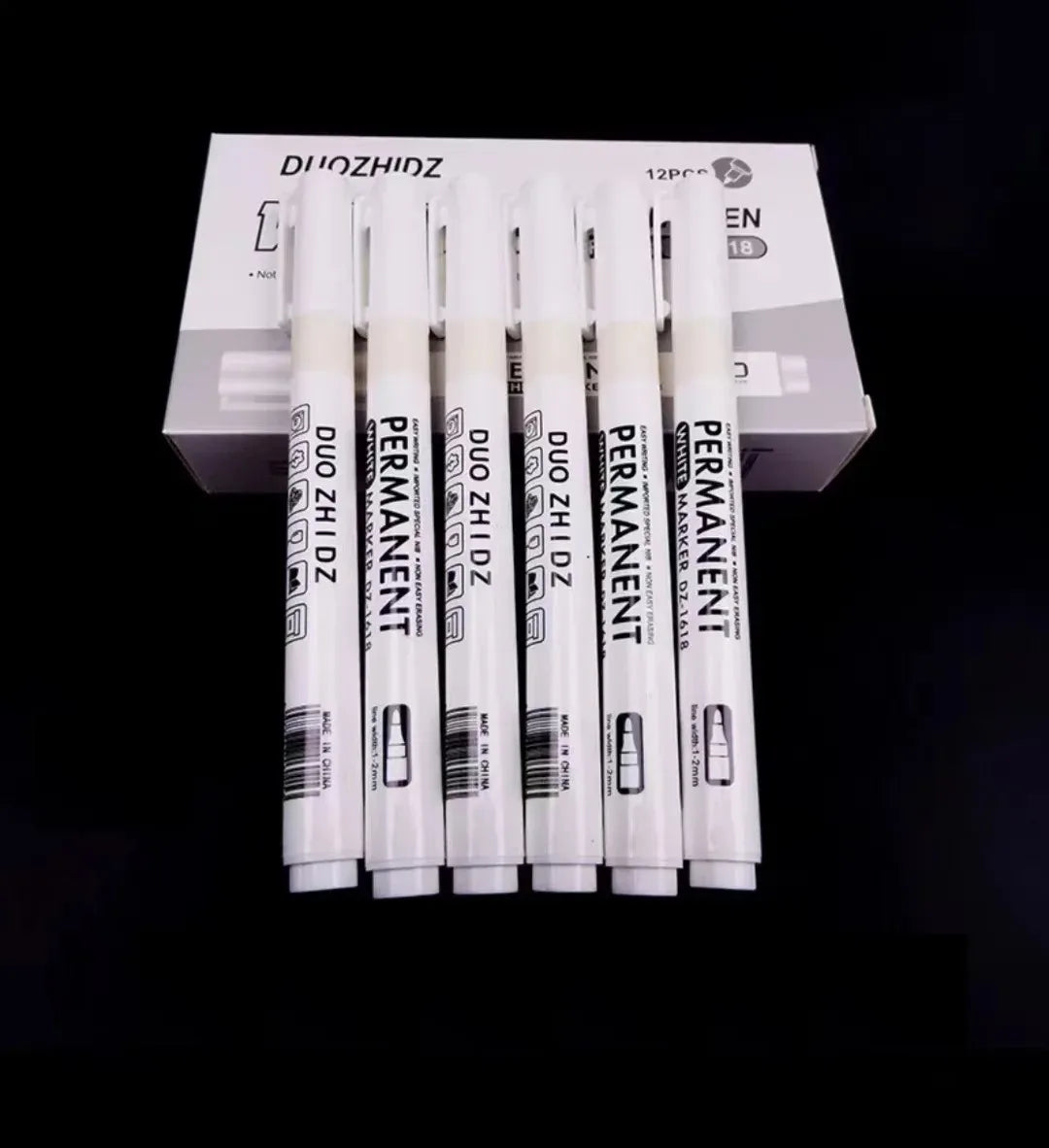 A box containing twelve black and white permanent paint markers for art, craft, and DIY.
