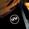 A close-up view of an Infiniti car door shadow light projector logo on a dark surface.