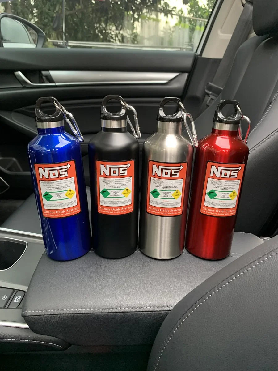 Three insulated stainless steel water bottles in blue, black, and red resting on a car interior panel.