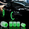 Une voiture noire avec des bouchons de valve de pneu verts lumineux, à côté de plusieurs bouchons de valve en plastique trans