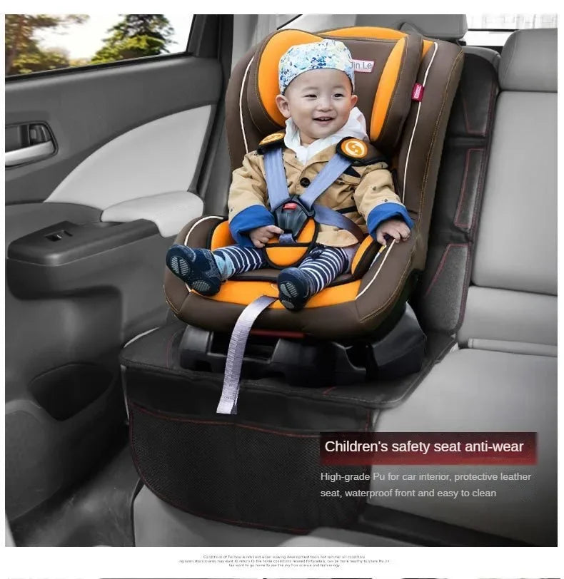 A smiling toddler is seated in a brown and orange car seat protector with blue fabric and safety harness installed in a car i