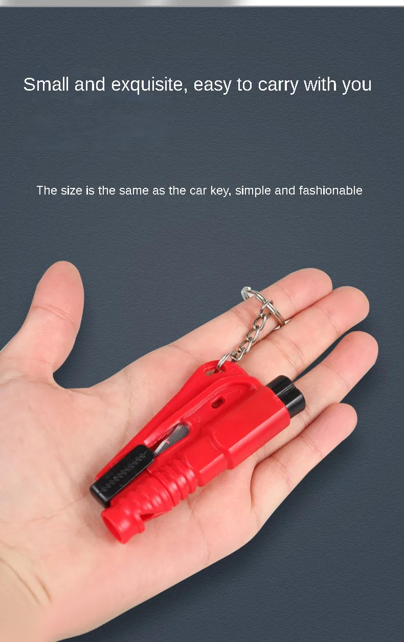 A hand holds a small red 3-in-1 car emergency safety tool kit with a metal chain attached.