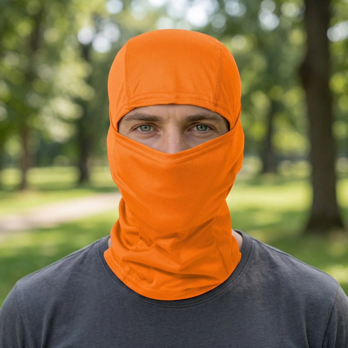 A man wearing an orange multi-functional stretchy balaclava cap for outdoor sports.
