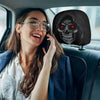 Una mujer sonriendo mientras usa un teléfono en un coche, con un diseño de calavera visible en el respaldo.
