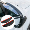 A close-up view of a car's rearview mirror with clear plastic rain and dust visors installed.