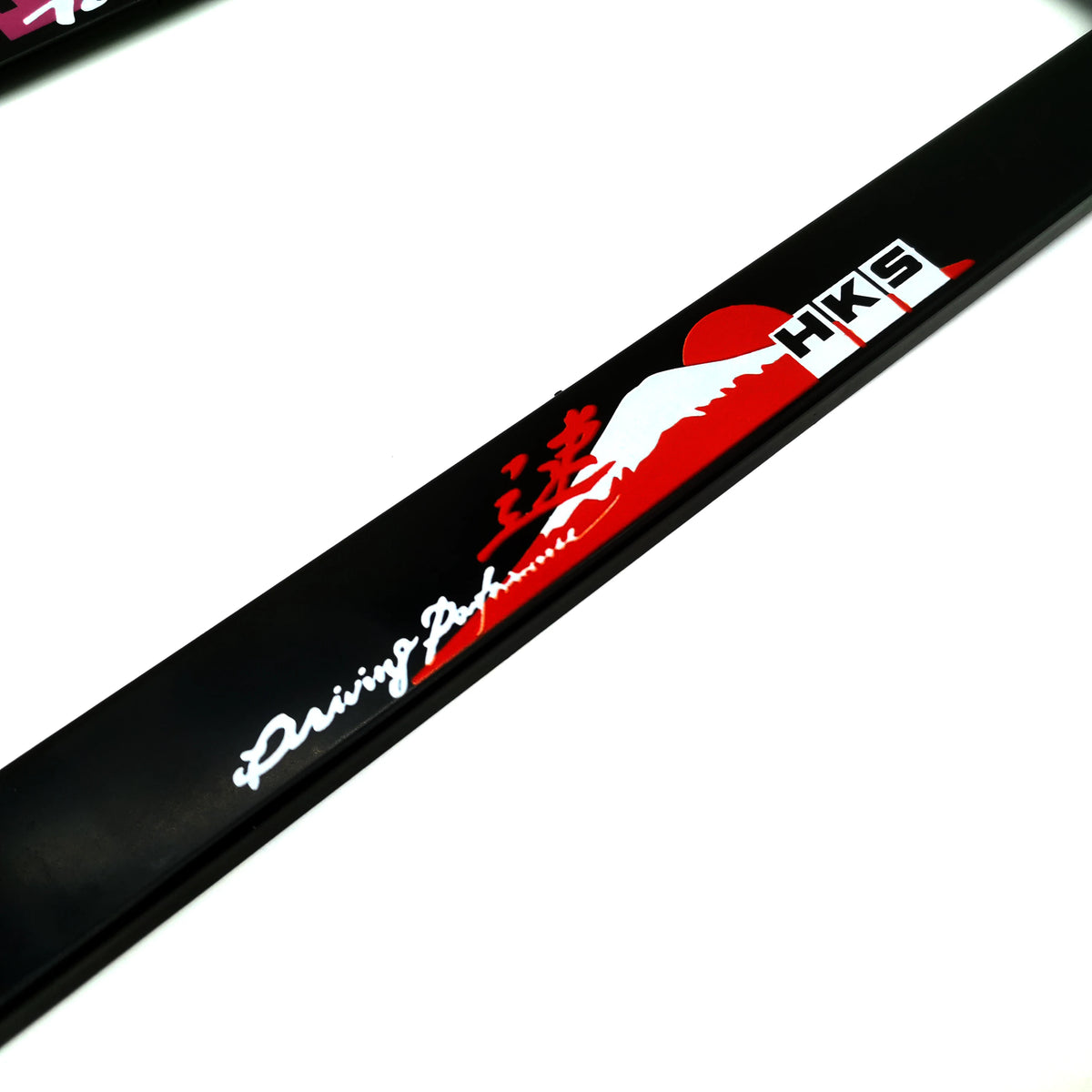 Black license plate frame decoration with red and white graphics featuring the HKS logo and Japanese characters.