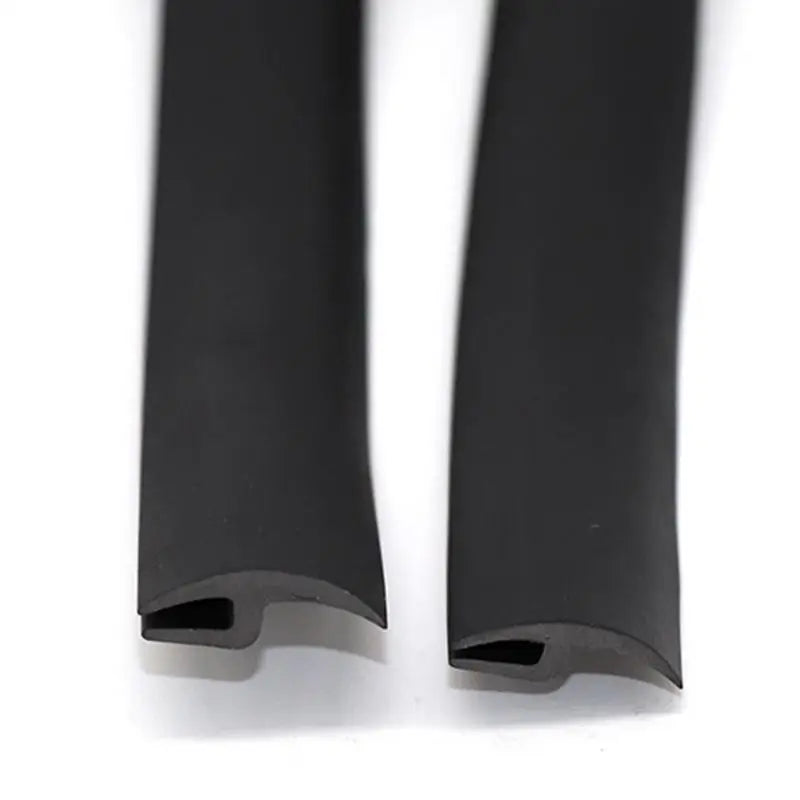 A close-up view of a black flexible windshield seal strip for noise reduction.