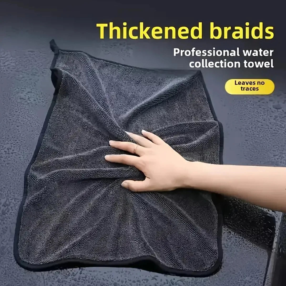 A hand is touching a black thickened braid professional water collection towel used for car drying.