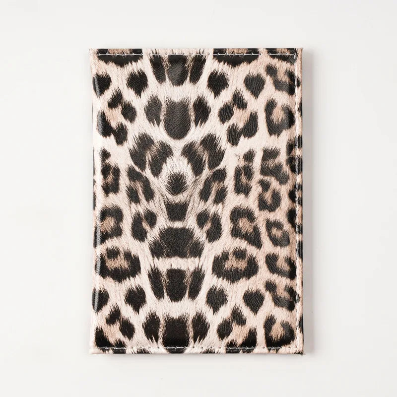 A black and tan leopard print passport holder with card slots.