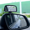 Miroir convexe noir fixé sur la porte d'une voiture, montrant la route devant.
