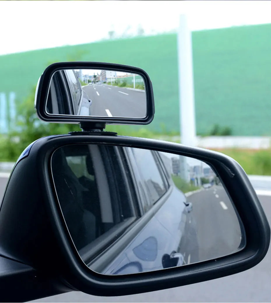 Miroir convexe noir fixé sur la porte d'une voiture, montrant la route devant.