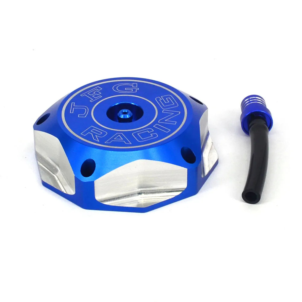 A blue and silver CNC aluminum fuel tank cap for a Honda motorcycle, shown next to its black fitting.