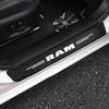 Black RAM carbon fiber door sill protection strips installed on a white vehicle body.