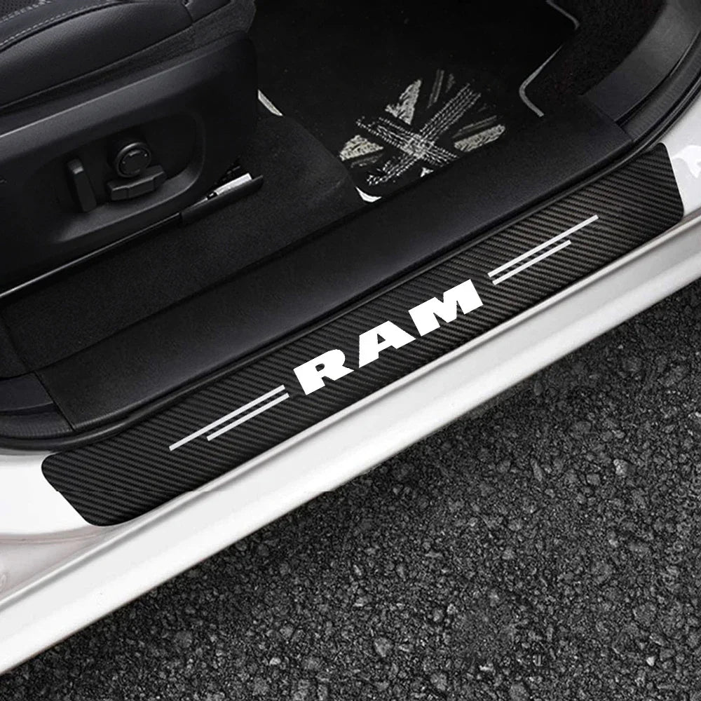 Black RAM carbon fiber door sill protection strips installed on a white vehicle body.