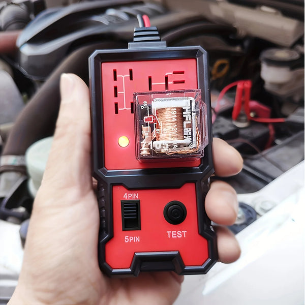A hand holds a portable 12V automotive relay tester device with a red and black casing and a visible relay component.