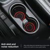 Close-up view of dual anti-slip car coasters with textured black and red accents inside a cup holder
