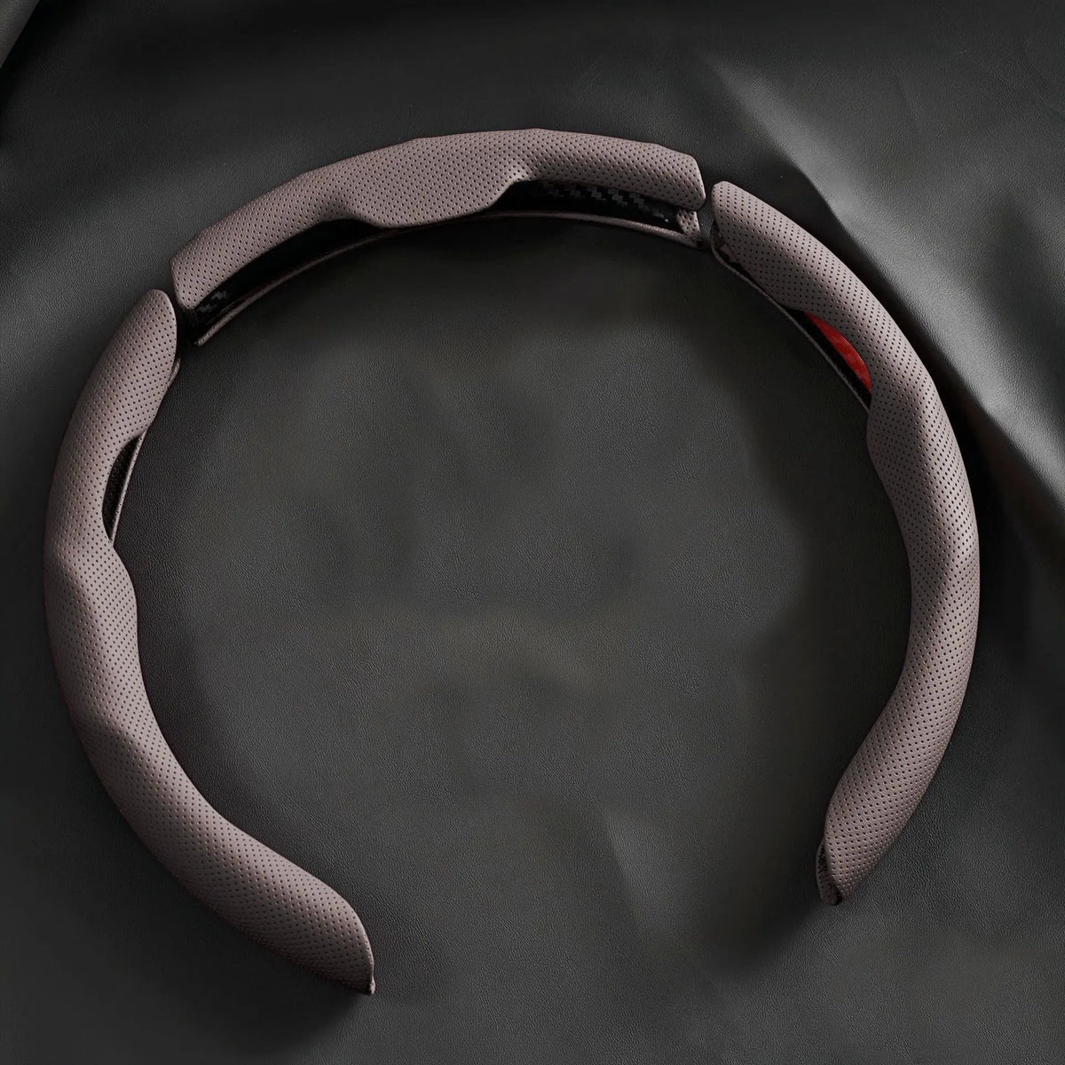 A gray breathable perforated leather steering wheel cover is shown from above.