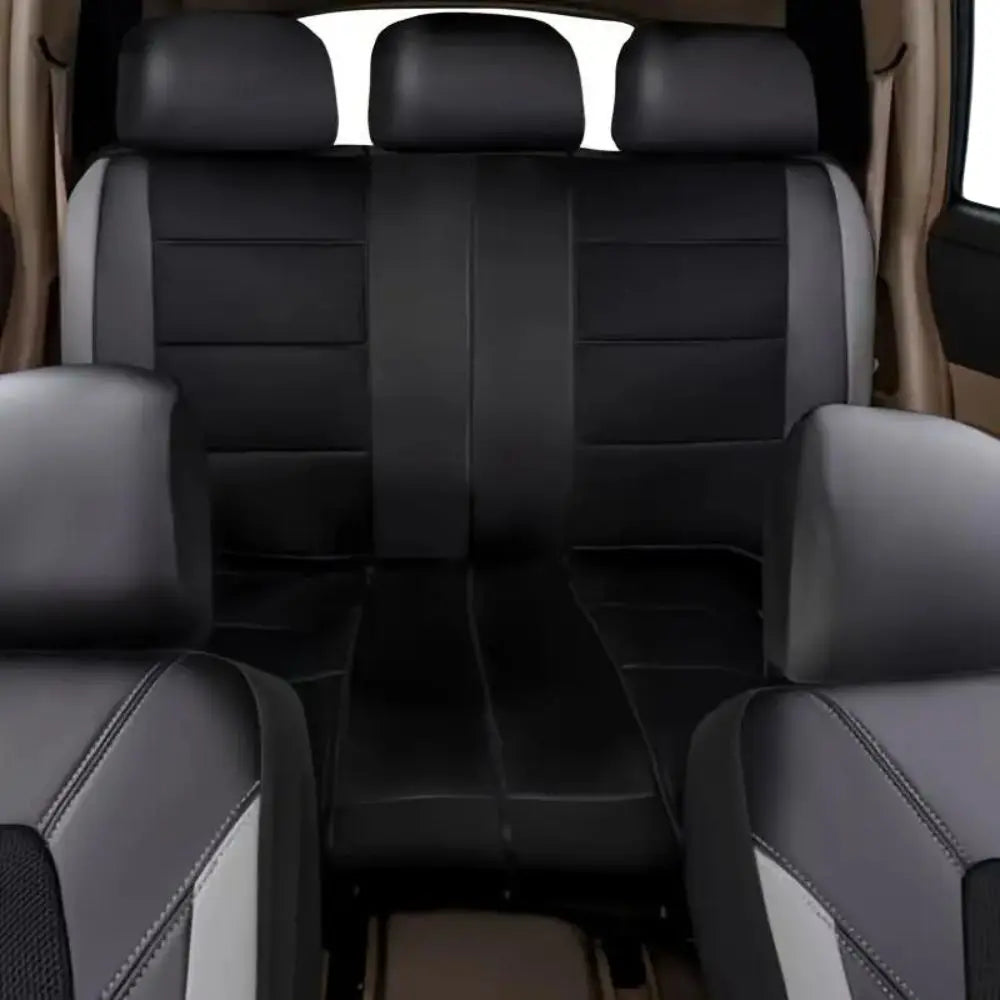 Interior view of a car with black leather seat covers and a front seat showing gray and white accents.