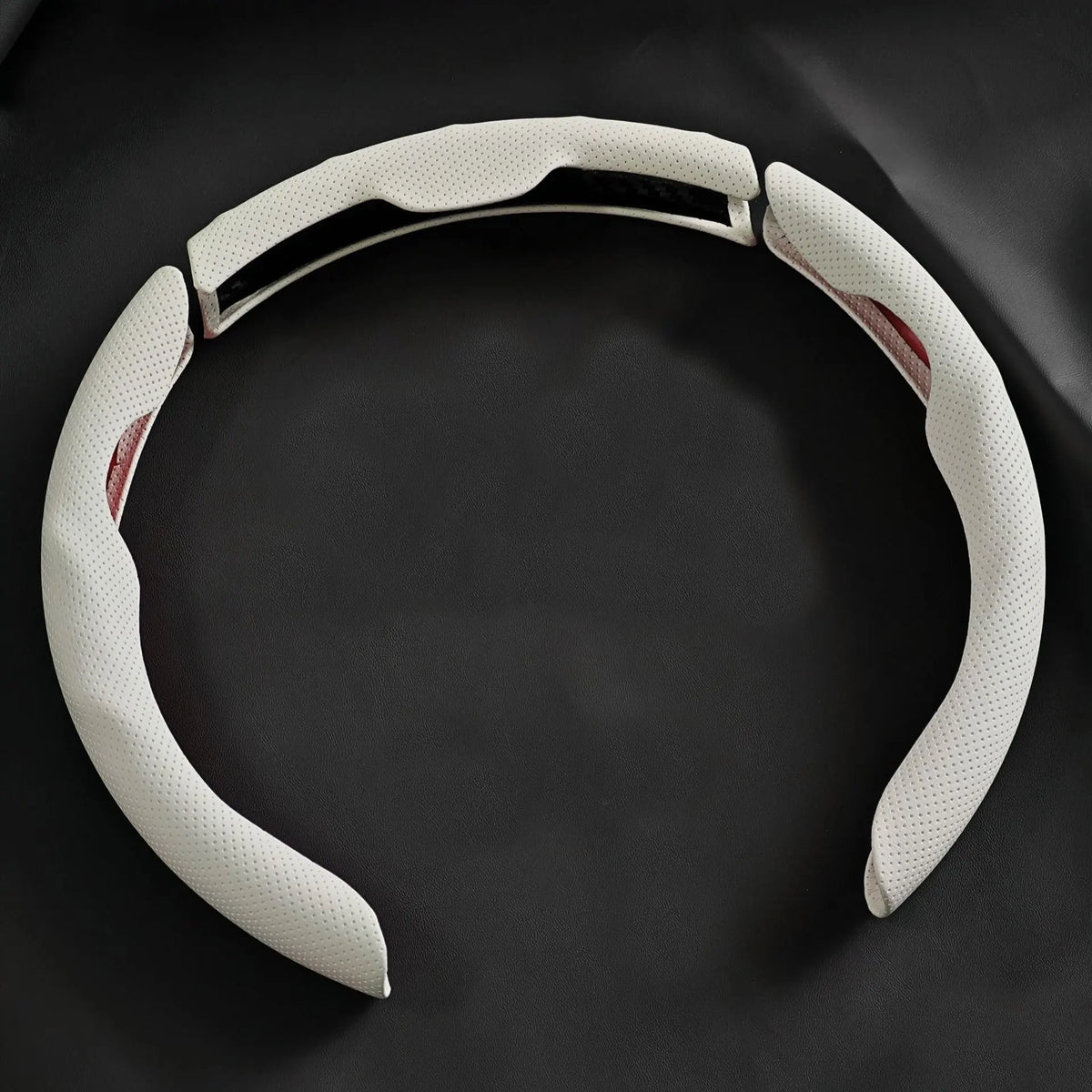 A white breathable perforated leather steering wheel cover is shown against a dark background.
